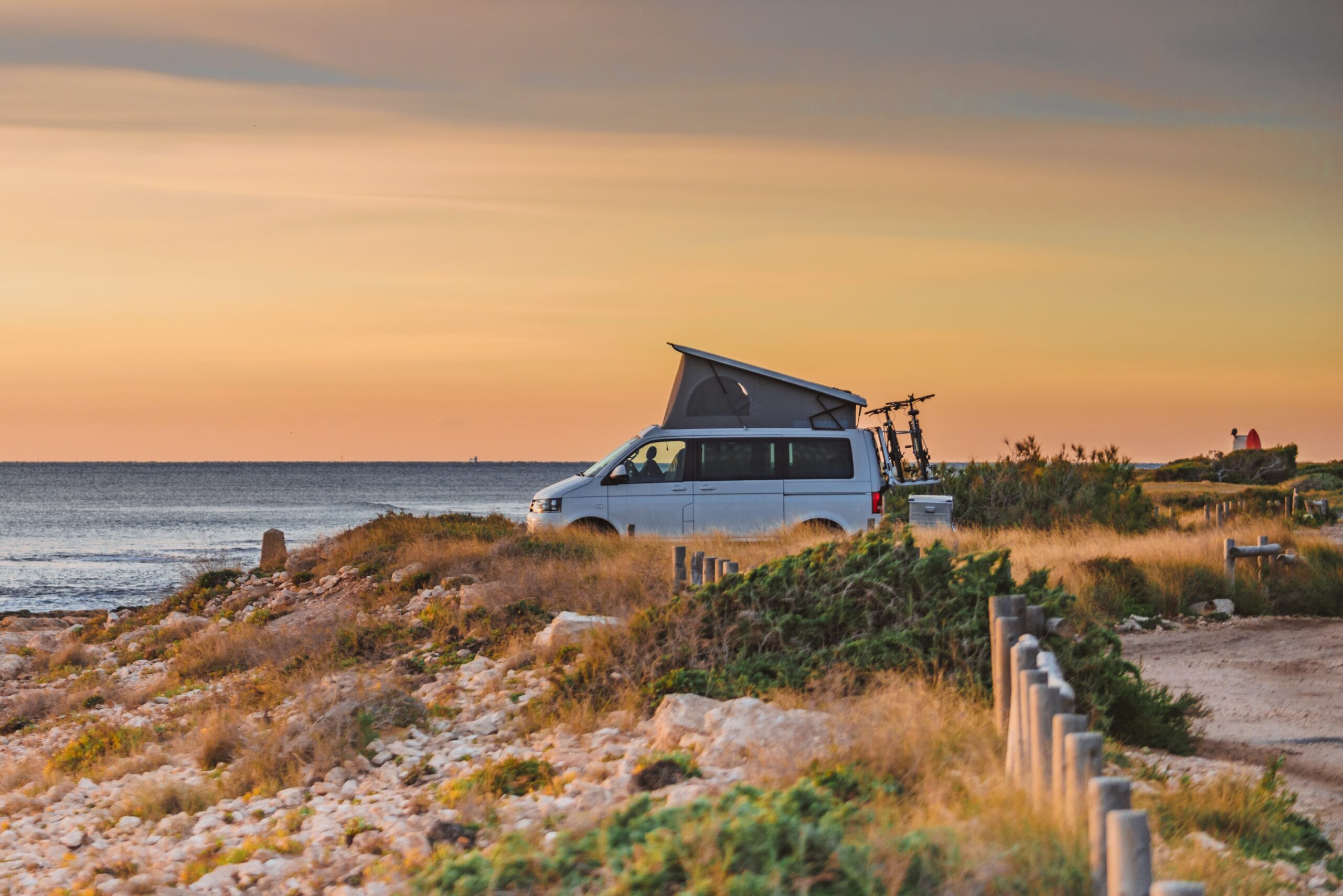 Pop Top Campervan Parked On Hilly Beach Landscape
