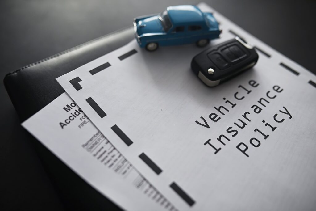 Vehicle insurance document with mini cars on top